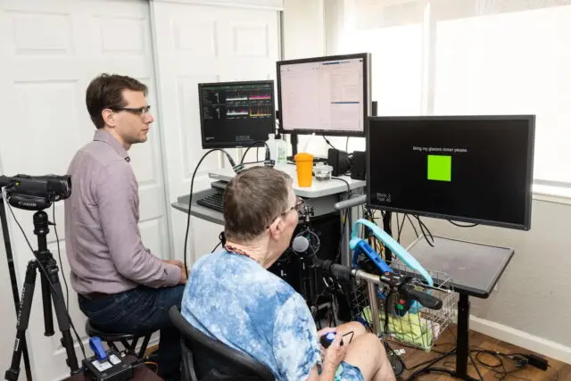 Pat Bennett, right, who is paralyzed from ALS, helps researchers at Stanford University train an AI that can translate her intended speech into sounds.